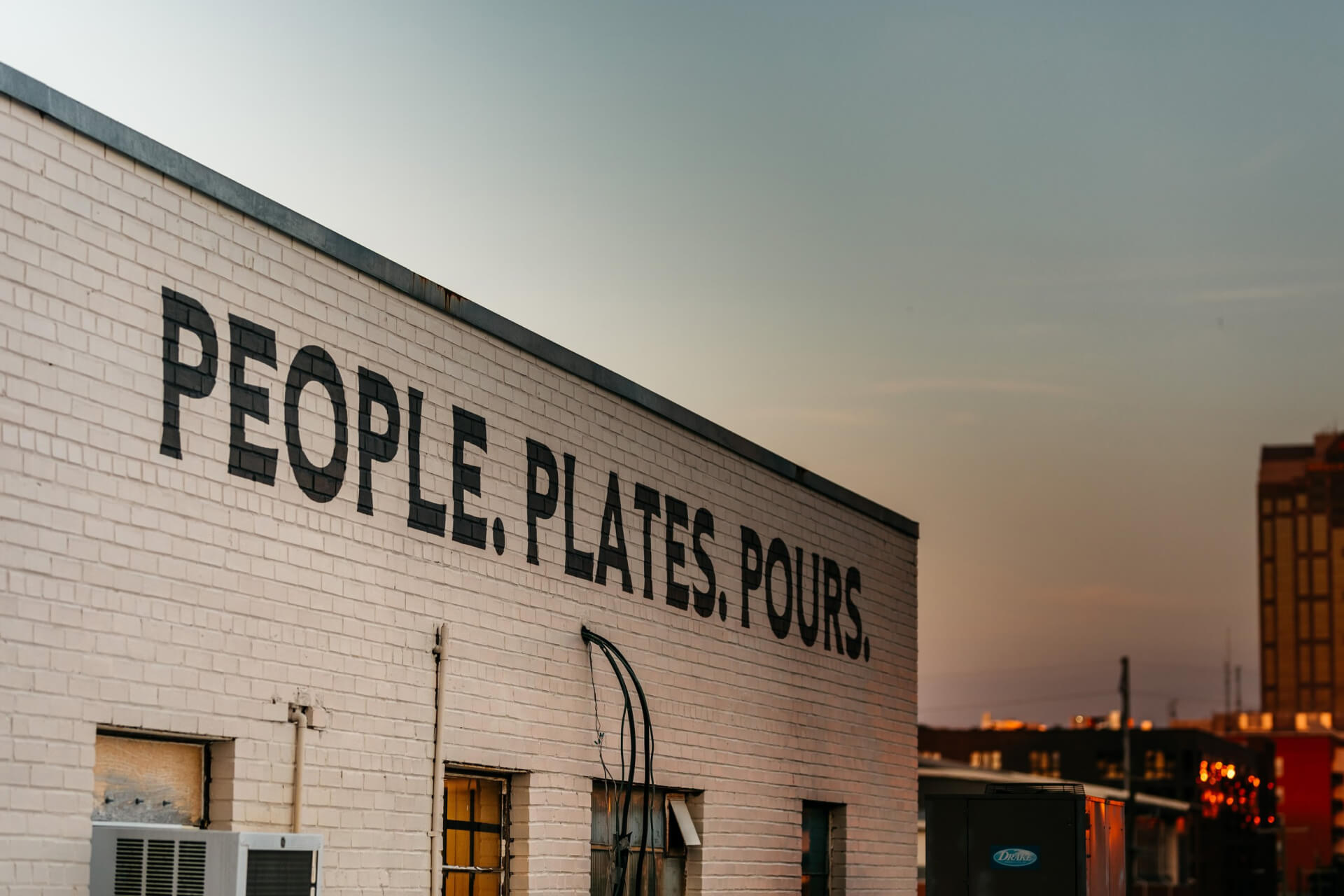 People, Plates & Pours signage painted on the wall at Wye Hill Brewing in Downtown Raleigh