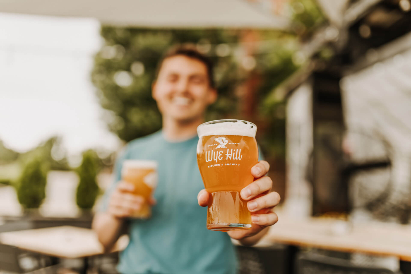 Server handing a freshly poured beer at Wye Hill Brewing in Downtown Raleigh