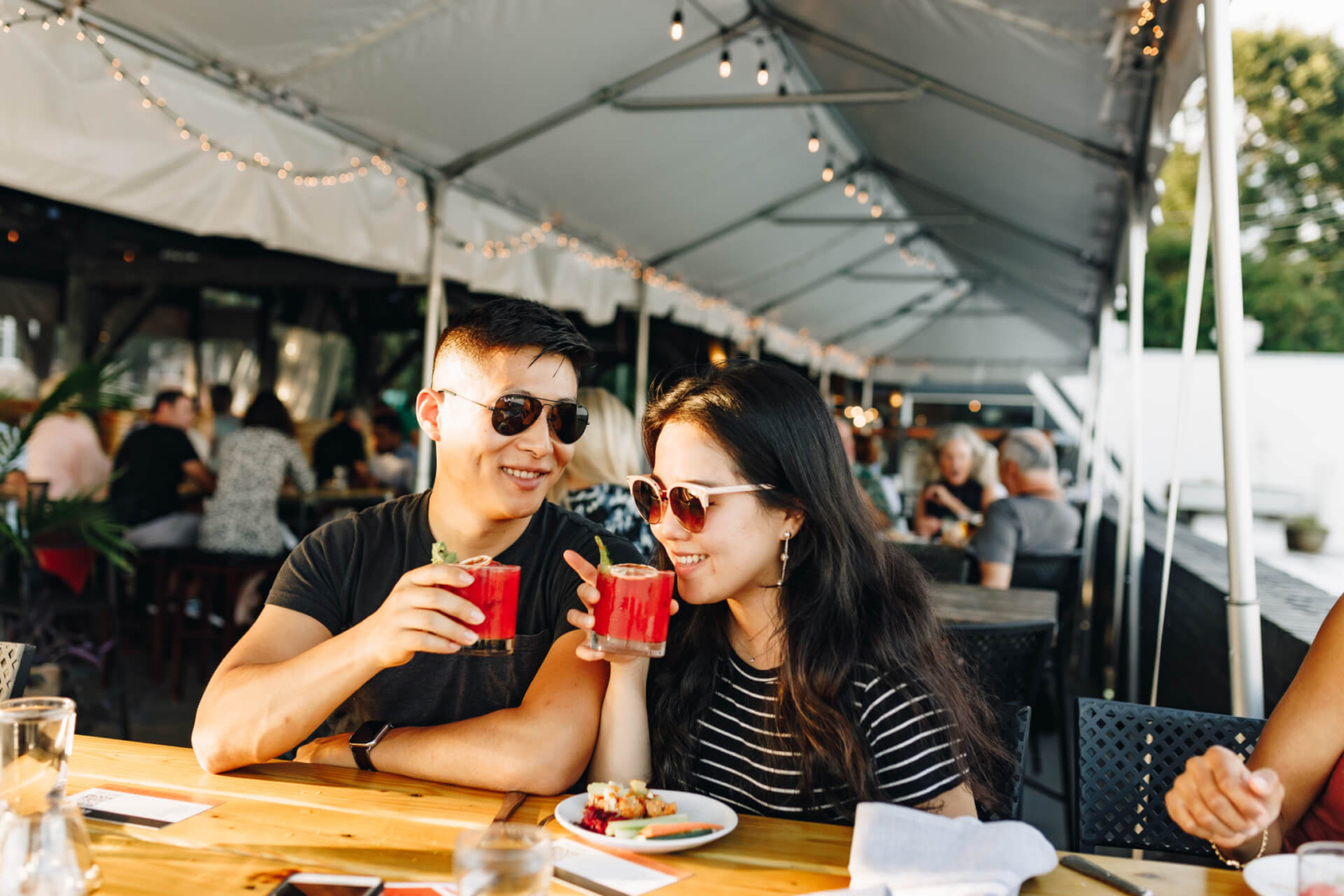 A couple enjoying their cocktails on the patio at Wye Hill Brewing in Downtown Raleigh